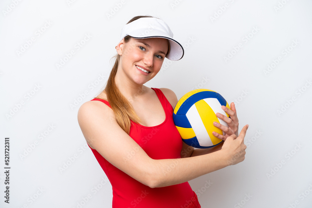 Young caucasian woman playing volleyball isolated on white background pointing back