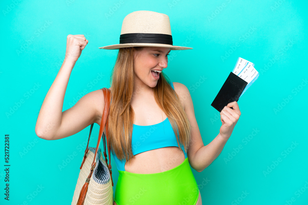 Traveler caucasian woman holding passport isolated on blue background celebrating a victory Traveler caucasian woman holding passport isolated on blue background celebrating a victory