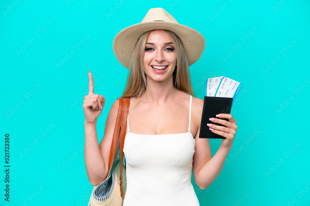 Blonde woman in swimsuit holding passport isolated on blue background pointing up a great idea Blonde woman in swimsuit holding passport isolated on blue background pointing up a great idea