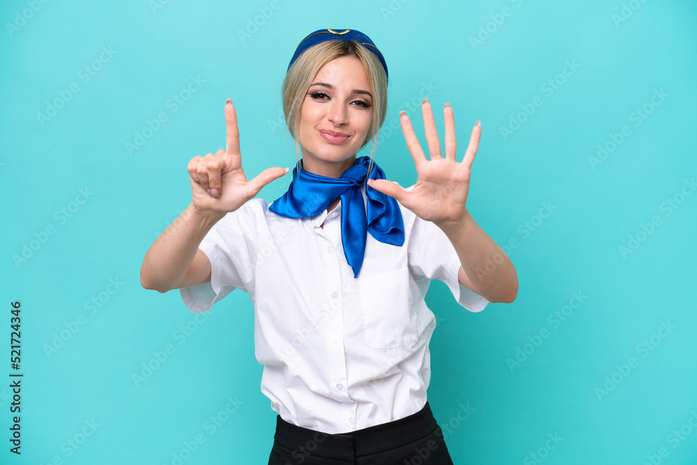 Airplane blonde stewardess woman isolated on blue background counting seven with fingers Airplane blonde stewardess woman isolated on blue background counting seven with fingers