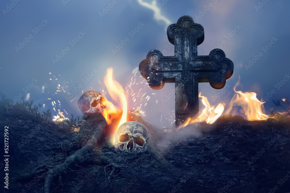 Fototapeta premium Cross and skull in the cemetery. Halloween image.