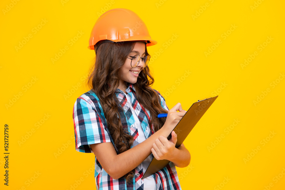 Teenager child painter in helmet with clipboard. Child in hard hat. Kid engineer on construction site. Renovation and repair. Teenager child painter in helmet with clipboard. Child in hard hat. Kid engineer on construction site. Renovation and repair.