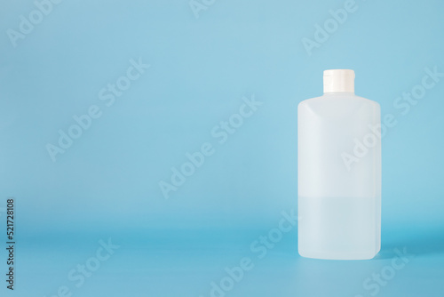 white plastic bottle for hand sanitizer on blue background.