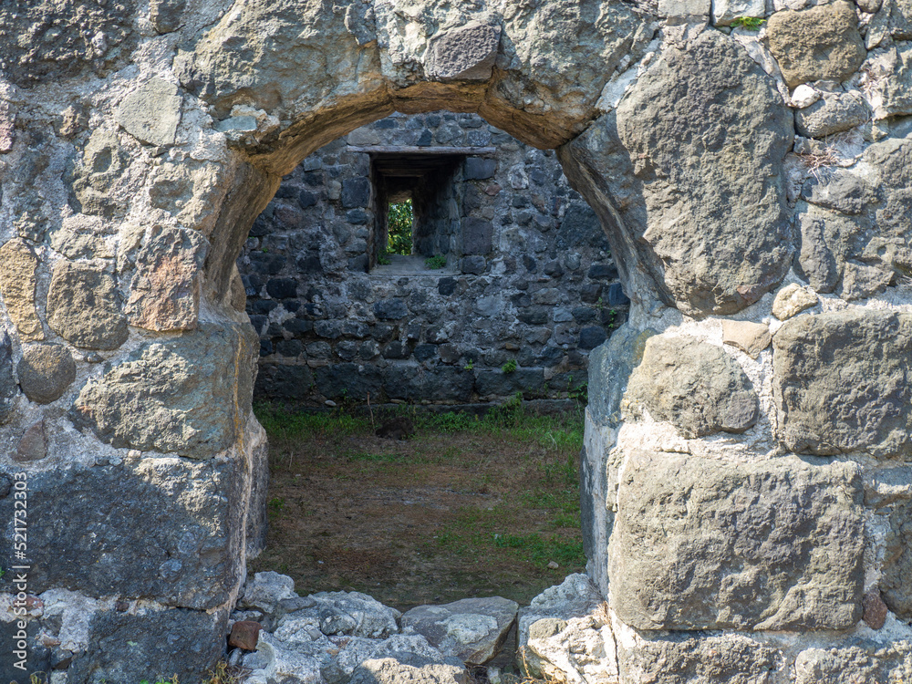 Remains of an old castle. Ancient fortifications made of stone. Museum in the open air. Medieval castle. Window in the wall.