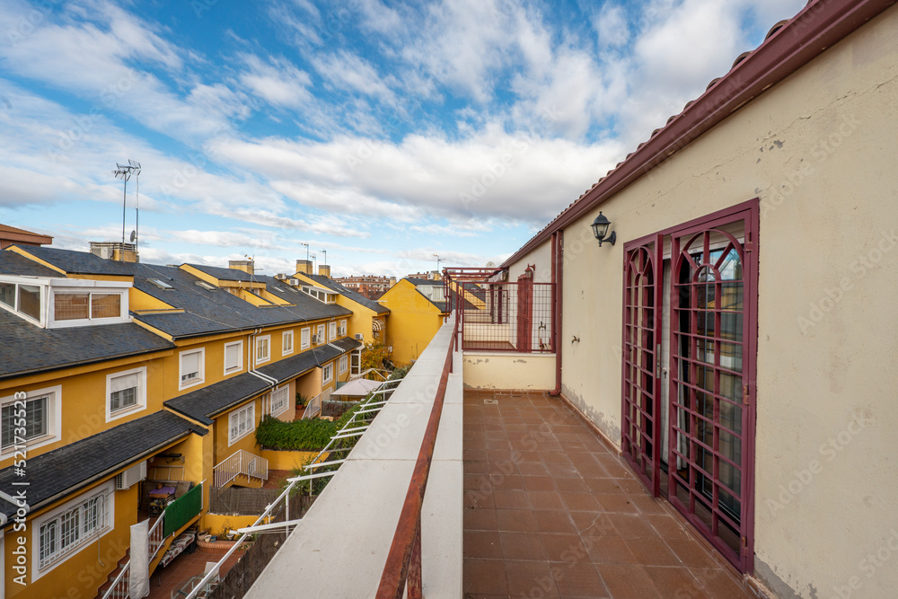 Viewpoint terrace of a single-family home with bars on the doors and views of a neighboring patio Viewpoint terrace of a single-family home with bars on the doors and views of a neighboring patio
