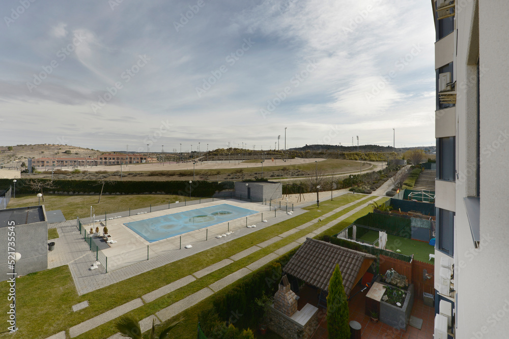 Views of a closed swimming pool and the courtyards of low-rise homes in an urbanization on the outskirts of a city