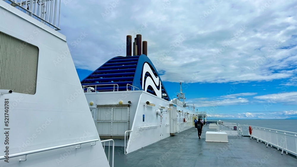 Naklejka premium The upper deck of the ferry departing from Canada to Vancouver Island is a clean white deck with a blue flag white stripes on a blue background This is the flag of the ferry everywhere sea-ocean.