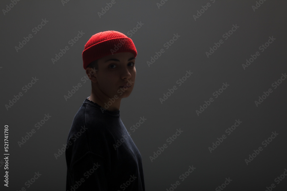 Girl with short hair wearing blouse and red hat against gray background. .. Girl with short hair wearing blouse and red hat against gray background. ..