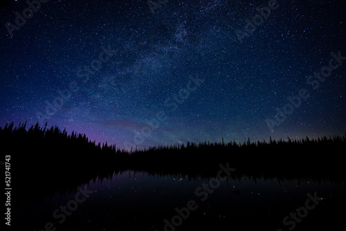 Milky way in night sky above lake