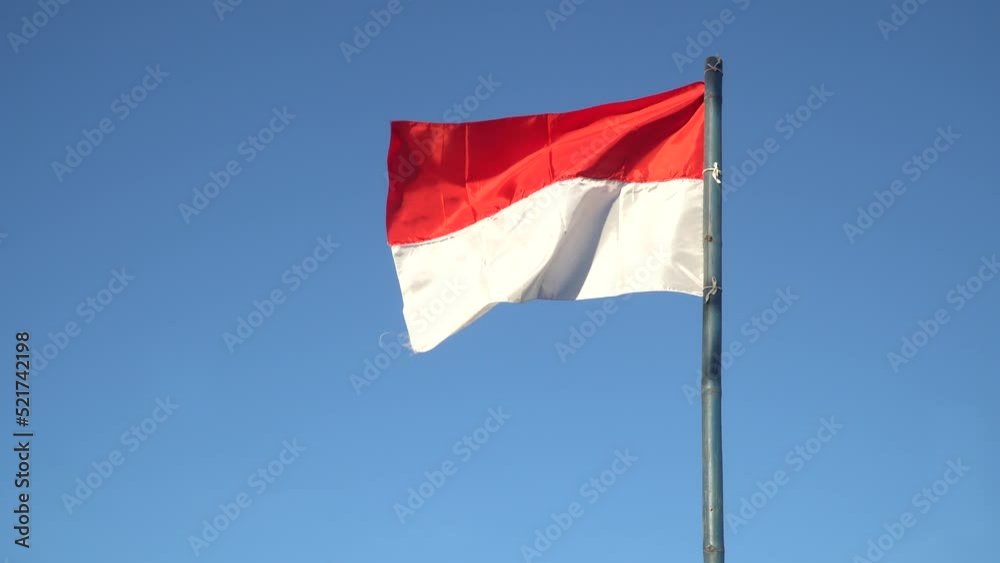 Red and white flag fluttering in the wind with blue sky Background Red and white flag fluttering in the wind with blue sky Background