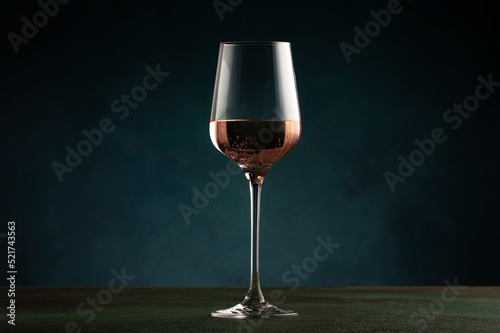 Rose wine from the zinfandel variety in wine glass on dark background, copy space photo