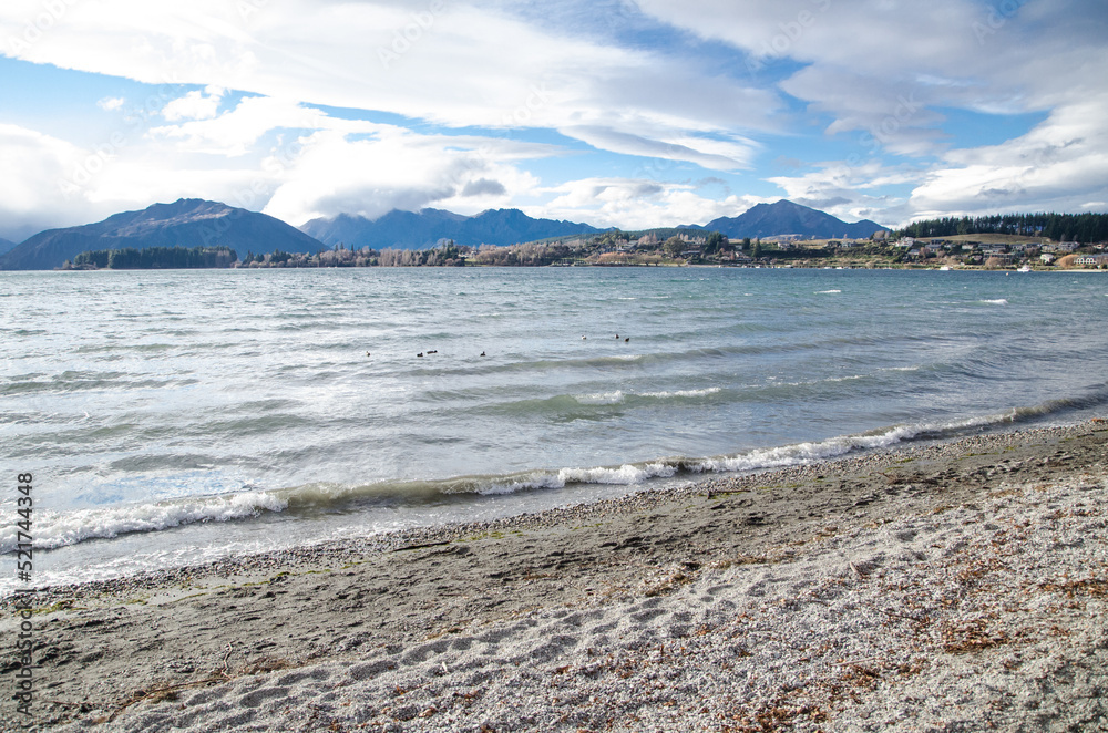 Rough sand beach with snowy mountain view on a cloudy day at South Island, New Zealand. Rough sand beach with snowy mountain view on a cloudy day at South Island, New Zealand.