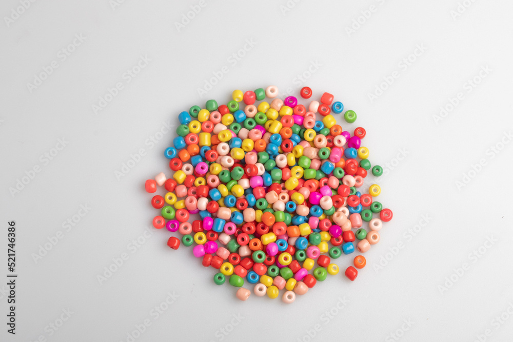 Assorted colored plastic beads on a white background.