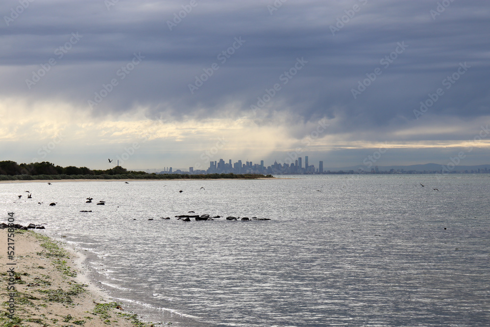 coastal landscape with rain cloud and city skyline of Melbourne