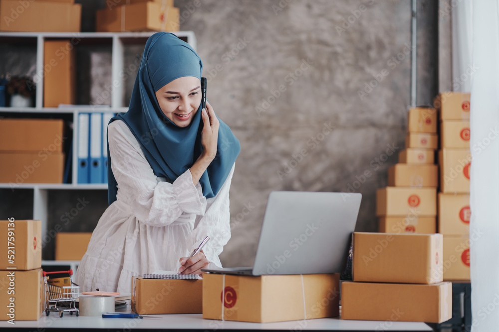 Small Startup Muslim Woman Checking parcels at work, freelancers, salespeople, checking production orders. Pack products to send to customers. Sell Ecommerce Shipping Ideas. Small Startup Muslim Woman Checking parcels at work, freelancers, salespeople, checking production orders. Pack products to send to customers. Sell Ecommerce Shipping Ideas.