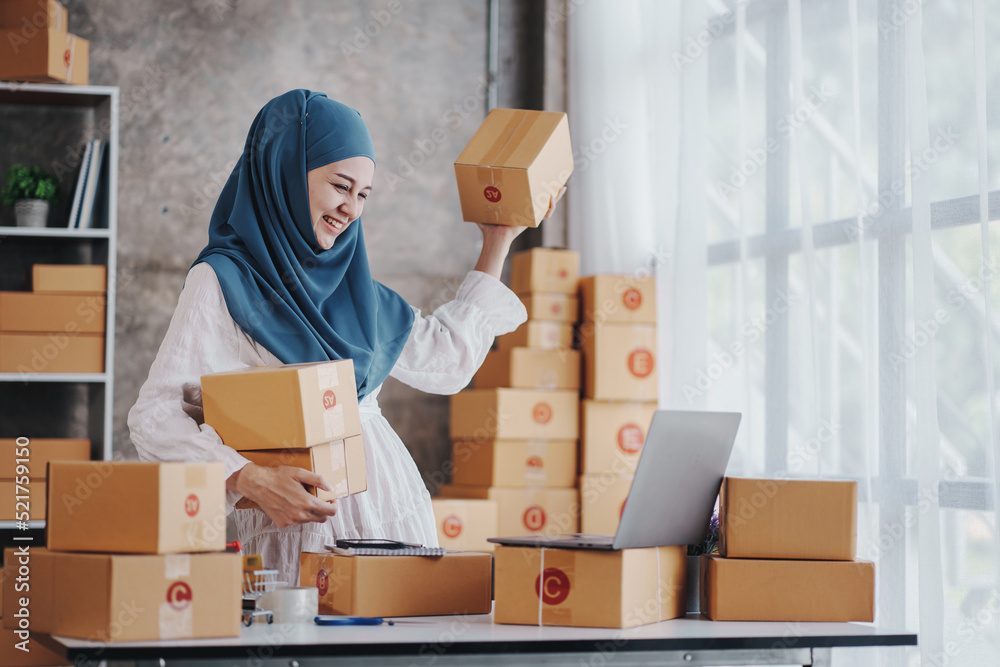 Small Startup Muslim Woman Checking parcels at work, freelancers, salespeople, checking production orders. Pack products to send to customers. Sell Ecommerce Shipping Ideas. Small Startup Muslim Woman Checking parcels at work, freelancers, salespeople, checking production orders. Pack products to send to customers. Sell Ecommerce Shipping Ideas.