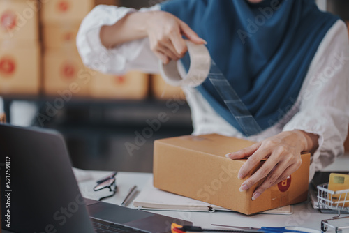 Small Startup Muslim Woman Checking parcels at work, freelancers, salespeople, checking production orders. Pack products to send to customers. Sell Ecommerce Shipping Ideas.