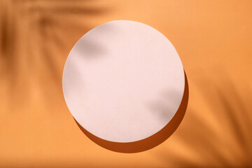 Mockup new naturalism with a podium pedestal on a summer sunny day and shadows from a palm tree on a pastel earthy orange background.