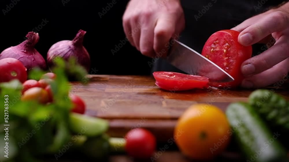 The chef is preparing a salad, slicing tomatoes. Video shooting slow motion The chef is preparing a salad, slicing tomatoes. Video shooting slow motion