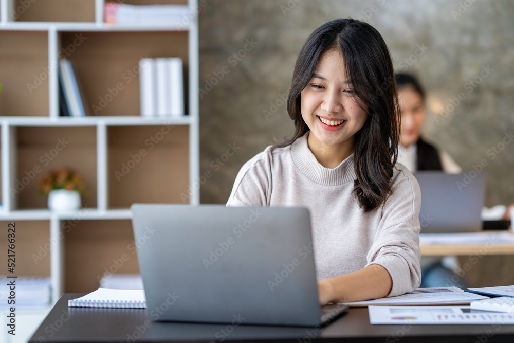 Asian businesswomen use laptops and smartphones in an open space office. Business concept. Data analysis, roadmap, marketing, accounting, auditing. Asian businesswomen use laptops and smartphones in an open space office. Business concept. Data analysis, roadmap, marketing, accounting, auditing.
