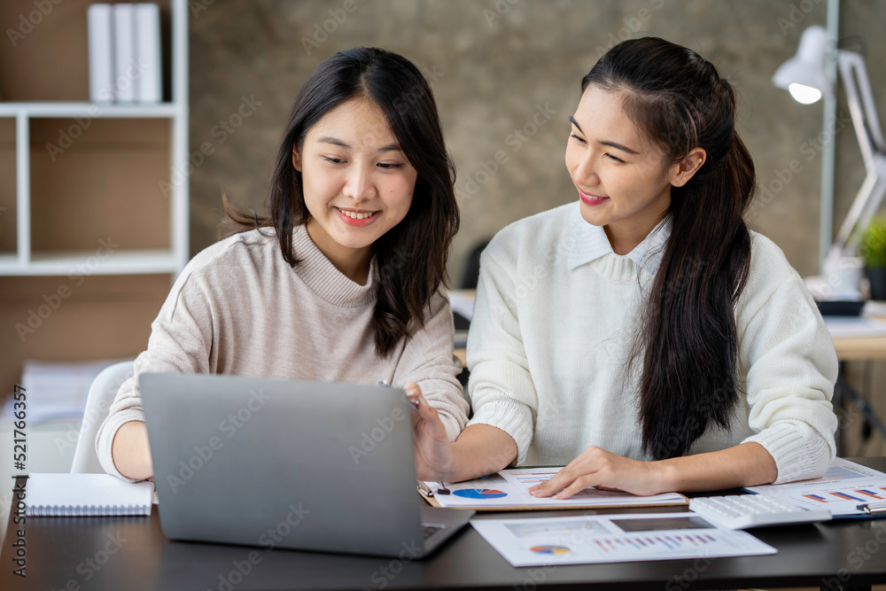 Two Asian businesswomen use laptops and smartphones in an open space office. Business concept. Data analysis, roadmap, marketing, accounting, auditing. Two Asian businesswomen use laptops and smartphones in an open space office. Business concept. Data analysis, roadmap, marketing, accounting, auditing.