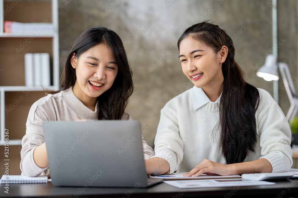 Two Asian businesswomen use laptops and smartphones in an open space office. Business concept. Data analysis, roadmap, marketing, accounting, auditing. Two Asian businesswomen use laptops and smartphones in an open space office. Business concept. Data analysis, roadmap, marketing, accounting, auditing.