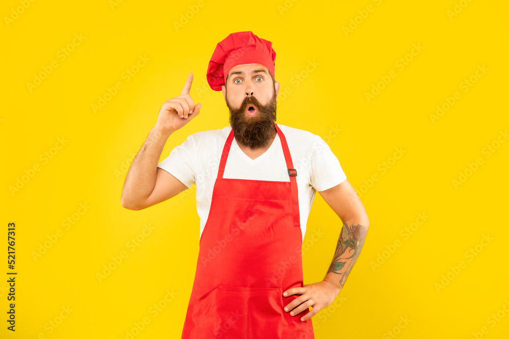 Surprised man in toque and apron got idea keeping finger raised yellow background, chef Surprised man in toque and apron got idea keeping finger raised yellow background, chef
