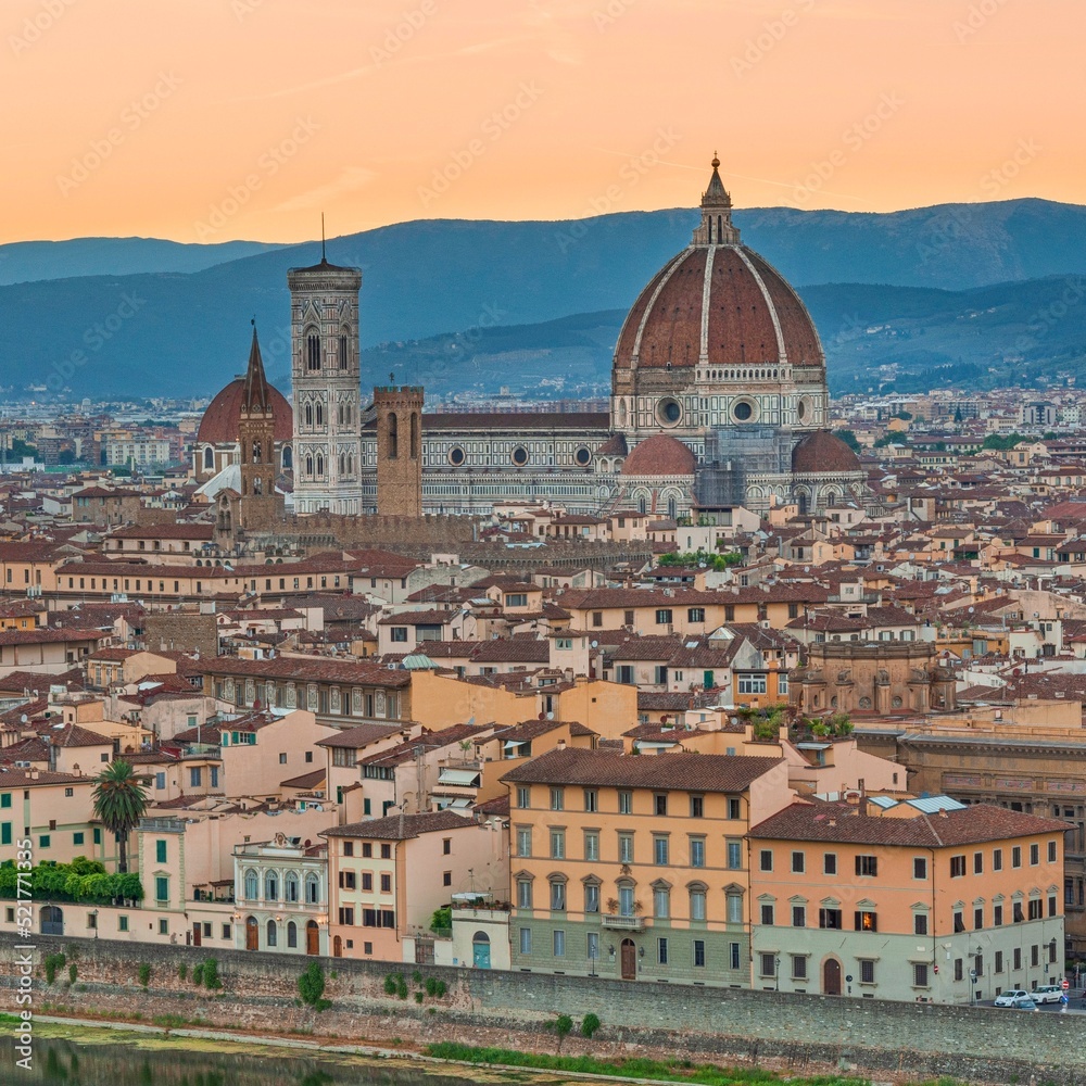 Gothic Florence's cathedral, the Duomo,  named in honor of Santa Maria del Fiore, Italy, Tuscany turns off above the roofs of nearby houses, at summer sunset