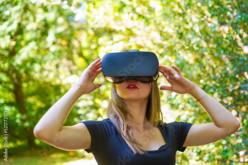 Wearing virtual reality glasses enjoying nature, imagining in the futuristic world in a park