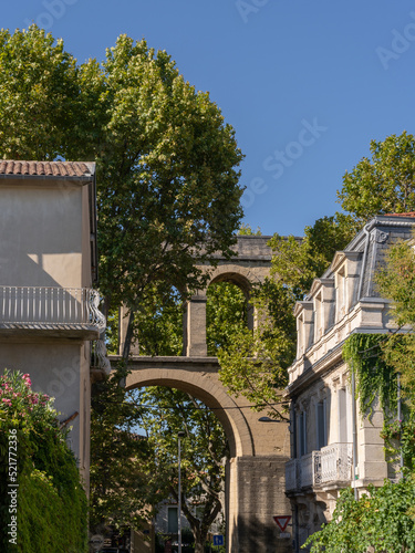 Scenic view of famous historic landmark St Clement aka Arceaux ancient stone aqueduct seen from a city street on a bright summer afternoon, Montpellier, France