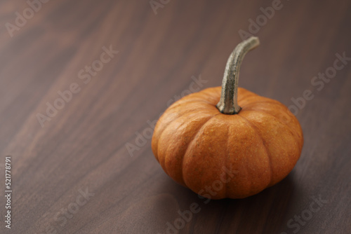 Cute orange pumpkin on wood table with copy space