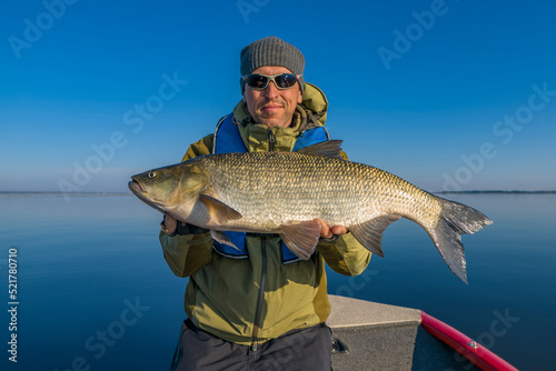 Asp fishing. Fisherman in sunglasses with aspius fish