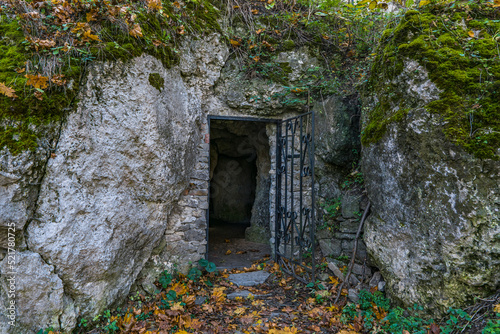 Fototapeta Naklejka Na Ścianę i Meble -  Dark cave entrance with metal gate in rock