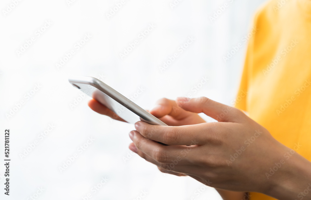 Hand holding smartphone with using social media on internet on sofa in living room. Hand holding smartphone with using social media on internet on sofa in living room.