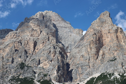 Coravara, Italy-July 16, 2022: The italian Dolomites behind the small village of Corvara in summer days with beaitiful blue sky in the background. Green nature in the middle of the rocks. © yohananegusse