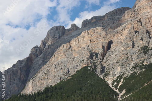 Coravara, Italy-July 16, 2022: The italian Dolomites behind the small village of Corvara in summer days with beaitiful blue sky in the background. Green nature in the middle of the rocks. © yohananegusse