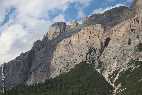 Coravara, Italy-July 16, 2022: The italian Dolomites behind the small village of Corvara in summer days with beaitiful blue sky in the background. Green nature in the middle of the rocks.