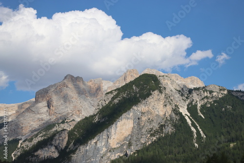 Coravara, Italy-July 16, 2022: The italian Dolomites behind the small village of Corvara in summer days with beaitiful blue sky in the background. Green nature in the middle of the rocks.