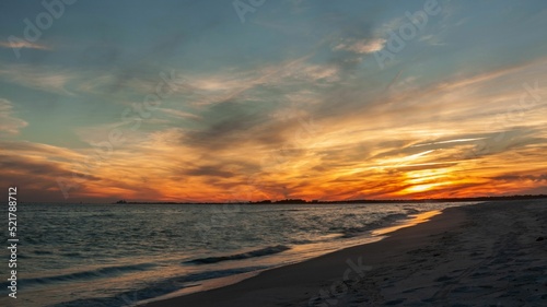 Fotografie Scenic view of Gulf of Mexico washing a sandy beach at sunset in Fort Pickens, F