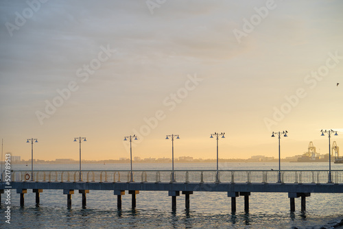 Close up of dodern concrete dock with lamp post during sunrise