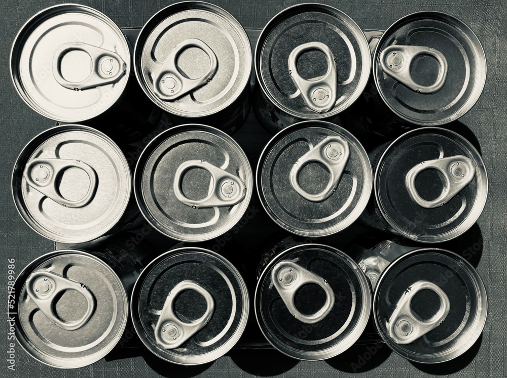 arranged tin cans with opener from above in black and white arranged tin cans with opener from above in black and white