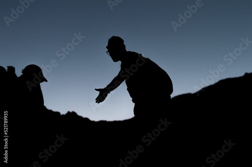 Group of people on peak mountain climbing, helping team work , travel trekking success during sunrise 
