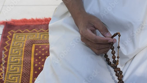 religious arab muslim man hold rosary wooden bead in hand for determine the number of prayer services to god allah in islam religion, concept for believe, trust, hope, peace in ramadan mubarak month photo