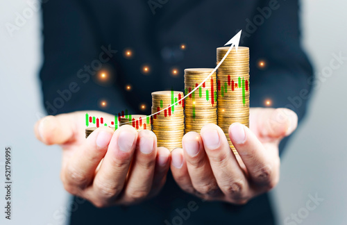 gold coins laid out in a graph on a businessman's hand. Business success concept, stock investment, wealth, digital transformation for technology. Money saving ideas in the age of virtual technology.