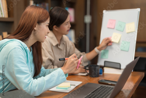 College education concept, Teenage girl looking vocabulary on whiteboard and writing on sticky note photo