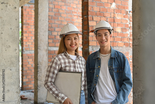 Portrait with a couple of young construction workers stand on the construction site.