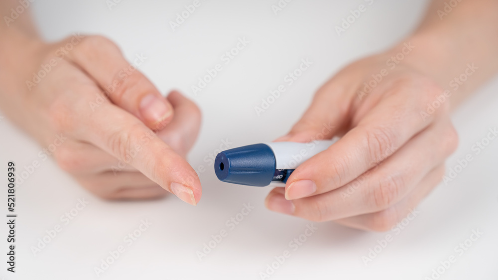 Caucasian woman doing a glucose test using a pen lancet. Caucasian woman doing a glucose test using a pen lancet.