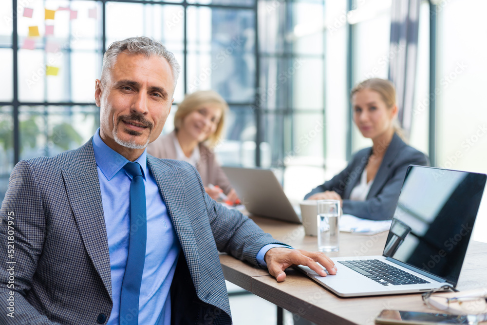 Businessman with colleagues in the background in office. Businessman with colleagues in the background in office.