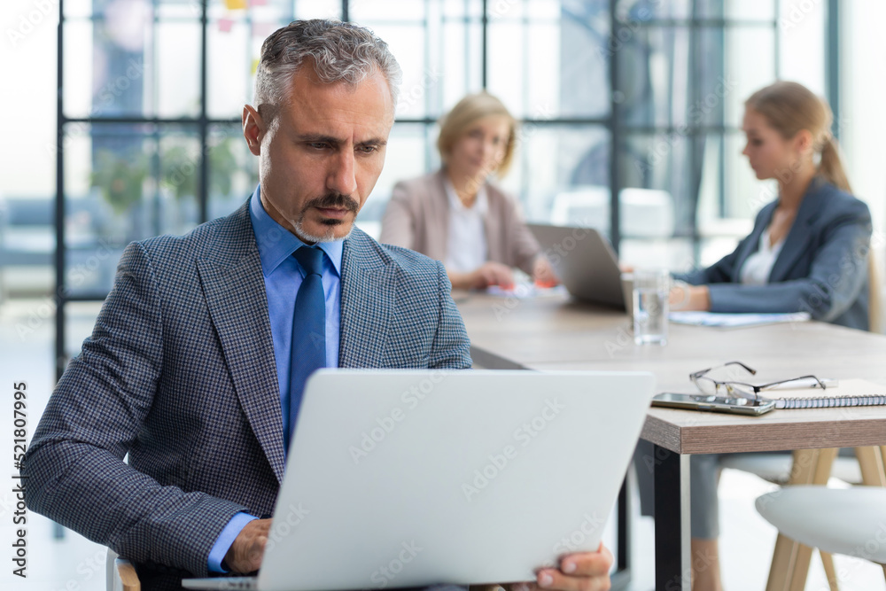Businessman with colleagues in the background in office. Businessman with colleagues in the background in office.
