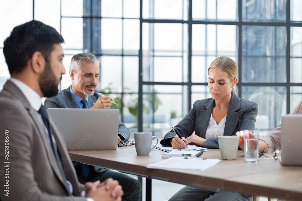 Business team discussing together business plans in office. Business team discussing together business plans in office.